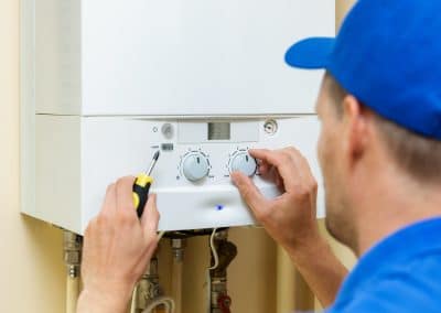 worker set up central gas heating boiler at home
